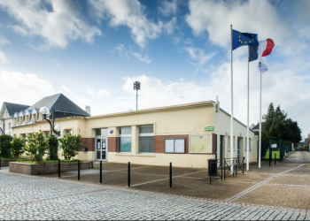 Façade de l'ancienne mairie de Rogerville avec drapeaux tricolores